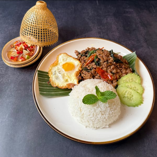 Bangkok Kaizen's Pad Krapow with minced pork, fried egg, rice, and cucumber slices.